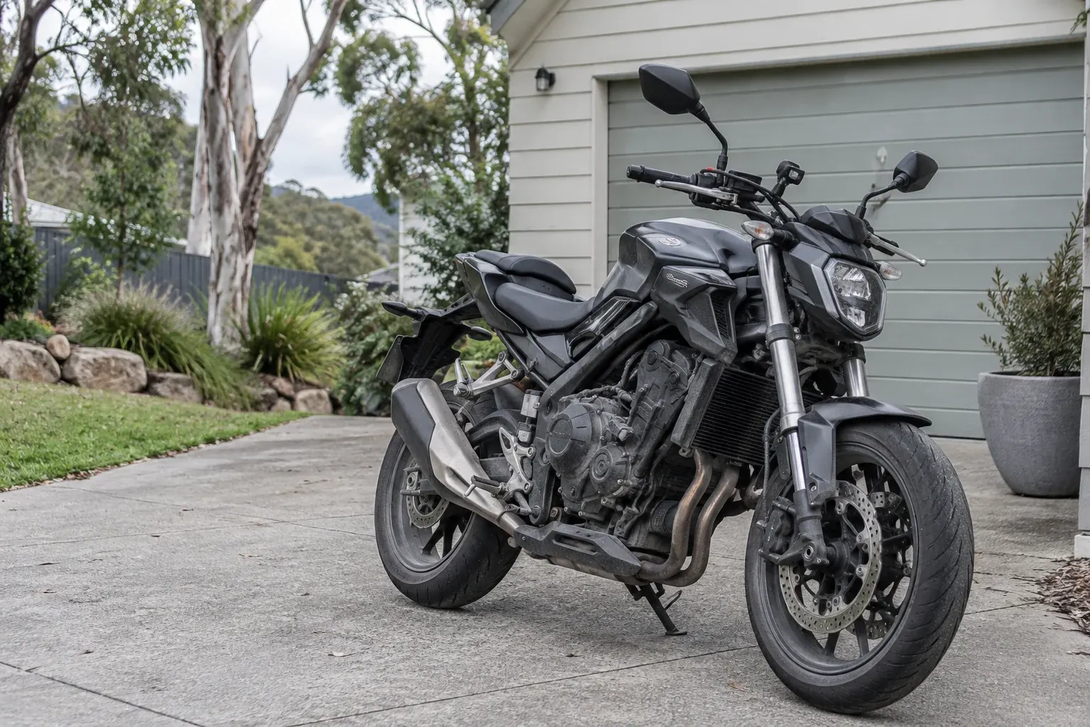 Used graphite motorcycle parked on an Australian suburban driveway